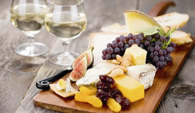 fruit and cheese board with 2 glasses of white wine